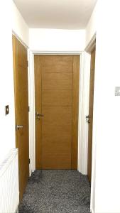 un pasillo con 2 puertas de madera en un edificio en 7 Venus Road (Room 7), en Londres