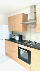a kitchen with wooden cabinets and a stove top oven at 7 Venus Road (Room 7) in London