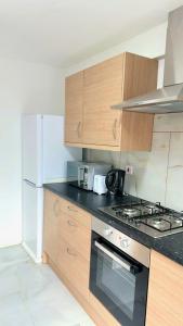 倫敦的住宿－7 Venus Road (Room 7)，厨房配有木制橱柜和炉灶烤箱。