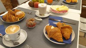 een tafel met gebakjes en een kopje koffie bij Mura 5&7 in Trieste