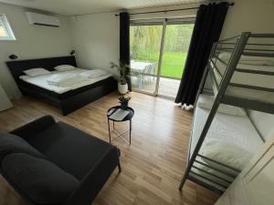 ein Wohnzimmer mit einem Bett und einem Sofa in der Unterkunft Lilla Fajans in Falkenberg