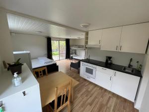 eine Küche und ein Wohnzimmer mit einem Tisch und einem Bett in der Unterkunft Lilla Fajans in Falkenberg