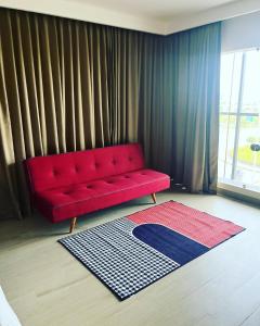 a red couch in a living room with a rug at PRESIDENCY AIRPORT HOTEL in Cochin