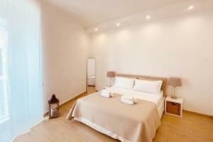 a white bedroom with a large bed with two pillows at casa Re Manfredi 12 in Bari