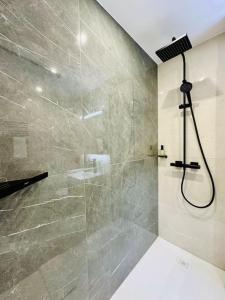 La salle de bains est pourvue d'une douche avec une porte en verre. dans l'établissement Modern City Studio with Balcony, à Zurich