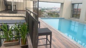 a balcony with a chair next to a swimming pool at PRESIDENCY AIRPORT HOTEL in Cochin