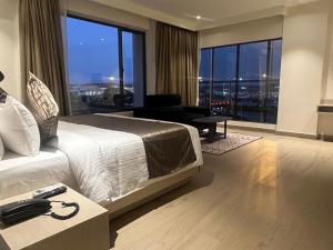a hotel room with a bed and a large window at PRESIDENCY AIRPORT HOTEL in Cochin