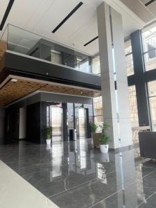 an empty lobby with potted plants in a building at PRESIDENCY AIRPORT HOTEL in Cochin