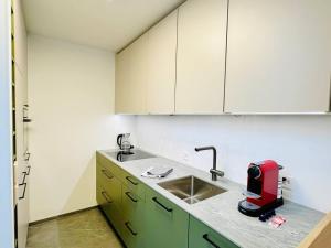 a kitchen with a sink and a red appliance on a counter at Modern City Studio with Balcony in Zürich