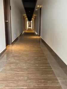 a long hallway in a building with a tile floor at PRESIDENCY AIRPORT HOTEL in Cochin