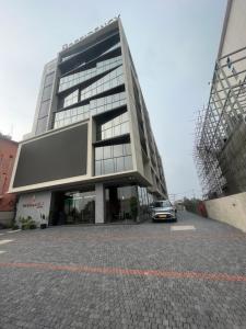 a car parked in front of a large building at PRESIDENCY AIRPORT HOTEL in Cochin