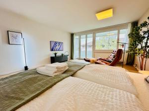 sypialnia z 2 dużymi łóżkami i oknem w obiekcie Modern City Studio with Balcony w Zurychu