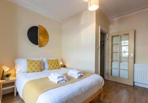 een slaapkamer met een groot bed en handdoeken bij Central 2bed Long Stays Parking Near Hospital in Southampton