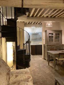 a living room with a staircase and a kitchen at Maison d'hôtes Campagne-Baudeloup in L'Isle-sur-la-Sorgue