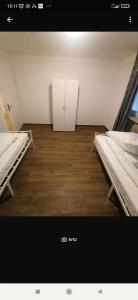 a room with two beds and a white cabinet at Entspannter Rückzugsort in Vilshofen an der Donau