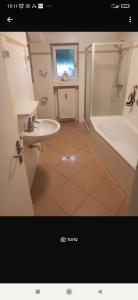 a bathroom with a tub and a sink and a bath tub at Entspannter Rückzugsort in Vilshofen an der Donau