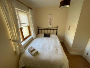 a small bedroom with a white bed with a window at Lough Rynn Rental in Mohill