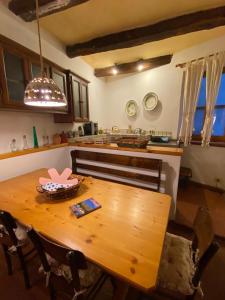 cocina con mesa de madera con sillas y barra en Casa Della Rosa en Pitigliano