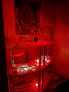 um quarto vermelho com uma mesa com luzes vermelhas em Romantic Woodhouse casita camping em Aguatona