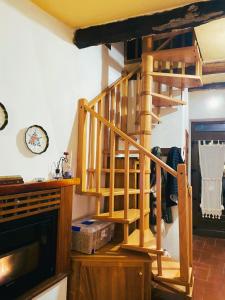 a wooden spiral staircase in a living room at Casa Della Rosa in Pitigliano