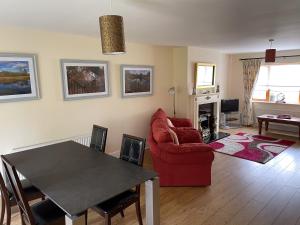 a living room with a red couch and a table at Lough Rynn Rental in Mohill