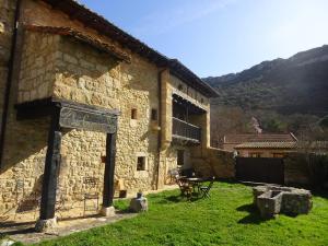 a stone building with a sign on the side of it at LA CASONA DE ESCALADA in Escalada