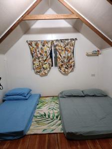 Habitación con 2 camas y ventana en Wooden Guest House GASA en Dauis