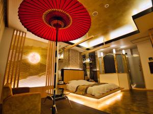 1 dormitorio con una gran sombrilla roja sobre una cama en SKY PARADISE スカイパラダイス　ラクエン en Oita