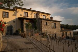 a stone house with a fence in front of it at La Locanda di Giulia in Arezzo