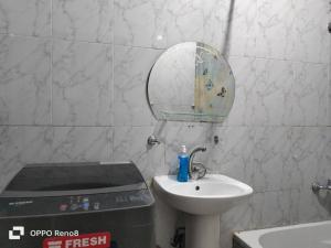 een kleine badkamer met een wastafel en een spiegel bij Cozy apartment Maadi Ring road in Caïro