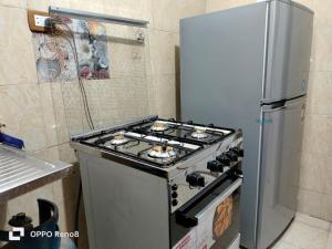a stove in a kitchen next to a refrigerator at Cozy apartment Maadi Ring road in Cairo +19 photos