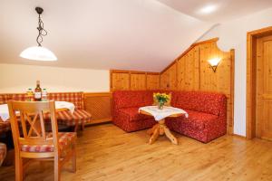 a living room with a red couch and a table at Oberaschenauer-Hof in Ruhpolding