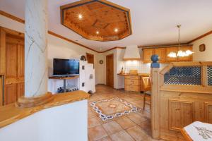 a large kitchen with wooden cabinets and a tv in a room at Oberaschenauer-Hof in Ruhpolding