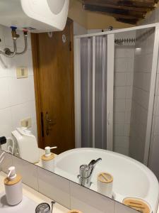 W łazience znajduje się umywalka i lustro. w obiekcie Casa Della Rosa w mieście Pitigliano