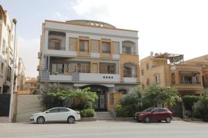 two cars parked in front of a building at Luxurious apartment - New Cairo in Cairo