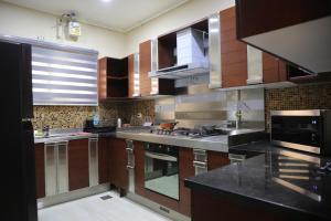 a kitchen with wooden cabinets and stainless steel appliances at Luxurious apartment - New Cairo in Cairo