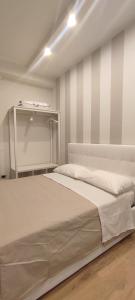 a bed in a room with a striped wall at Portonaccio suite - Stazione Tiburtina - Università - Metro B in Rome