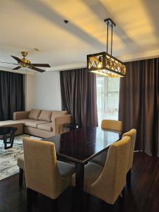 a dining room with a table and chairs and a couch at Forest Lodge at Camp John Hay privately owned - Deluxe Queen Suite with balcony and Parking 269 in Baguio