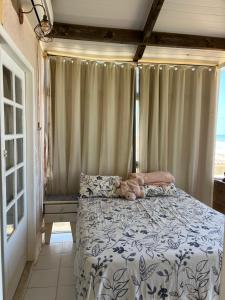a bedroom with a bed with a teddy bear on it at Casa Frente Mar in Arembepe