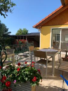 eine Terrasse mit einem Tisch, Stühlen und Blumen in der Unterkunft Gästehaus Gnant in Winten