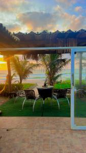 a patio with two chairs and a table with a view of the beach at Casa Frente Mar in Arembepe