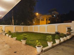 a row of potted plants inront of a white fence at Raj Residency Inn in Gurgaon