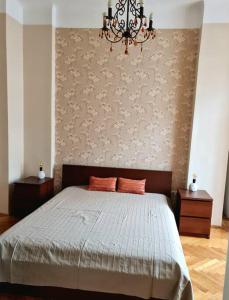 sypialnia z łóżkiem i żyrandolem w obiekcie Terrific Tátra Apartment w Budapeszcie