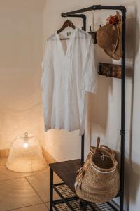 a black rack with a white shirt and a basket at Cala Cala Rooms,Restaurant & Farm Experience in Procida