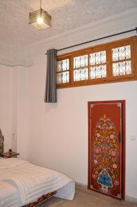 Schlafzimmer mit einem Bett und einem Fenster in der Unterkunft Dar Al Mardi Fes in Fès
