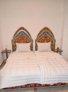 ein Schlafzimmer mit einem großen Bett mit zwei Kissen in der Unterkunft Dar Al Mardi Fes in Fès