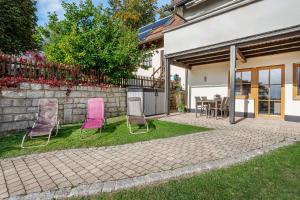 un patio con 2 sillas y una mesa en Ferienwohnung im Naturpark Steinwald en Erbendorf