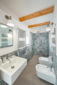 La salle de bains est pourvue de 2 lavabos et d'une douche. dans l'établissement Cala Cala Rooms,Restaurant & Farm Experience, à Procida