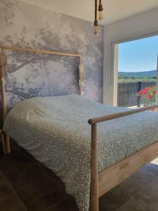 1 dormitorio con 1 cama con pared y ventana en ღ L'Orb Enchanté - Piscine chauffée, Clim, Netflix, en Cessenon