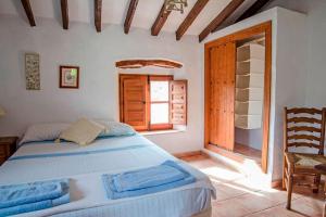 Canillas de AceitunoにあるCasa del Algarroboの大きなベッドと窓のある寝室 +14枚の写真